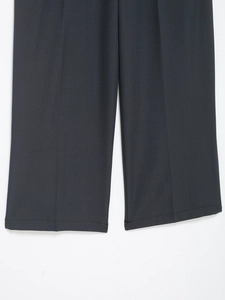 Detailed macro view of the straight stitching and fabric texture on black wide-leg trousers