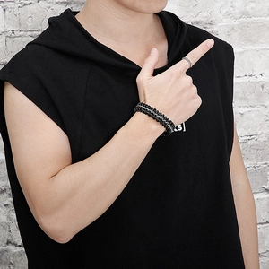 Detail of woven black leather bracelet with silver metal chain on a male model's wrist