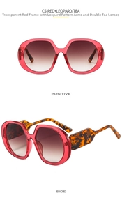 Detail view of red oversized sunglasses with leopard print temples and tea gradient lenses