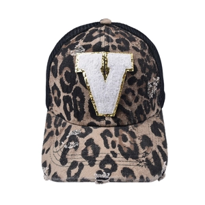 Detail of leopard print baseball cap with white chenille letter V and gold glitter edge