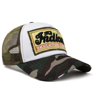 Side view of camo mesh trucker hat with embroidered Indian Skeleton patch on white crown