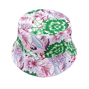 Close-up of pink bucket hat with green and purple floral patterns on cotton fabric