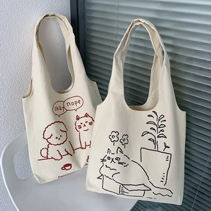 Detail of white canvas tote bags featuring minimalist cat and dog cartoon illustrations