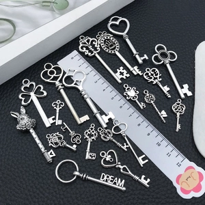 Detailed view of vintage alloy key pendants in antique silver with size reference ruler
