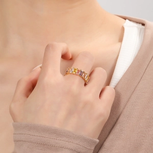 Gold plated eternity ring with colorful rectangular crystals shown on a model hand