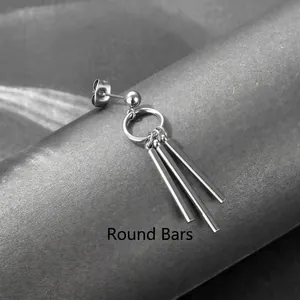 Macro shot of stainless steel earring with hanging round bars on textured surface