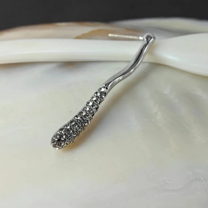 Macro shot of silver stud earring with 18k gold plating and shimmering diamond paving