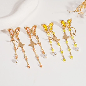 Elegant butterfly drop earrings with zircon crystals and pearls on light background