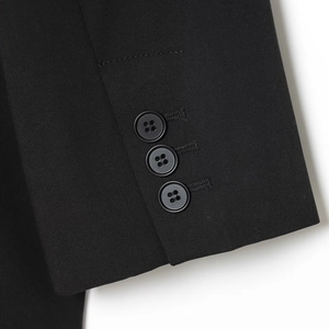Close-up of black blazer cuff featuring three four-hole buttons on high-quality woven fabric