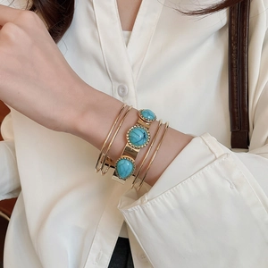 Bohemian multilayer gold bangles with marble textured turquoise stone detail on the wrist
