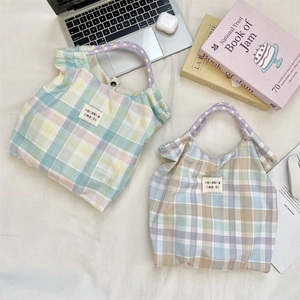 Detailed view of floral canvas tote bags with checkered patterns and woven handles