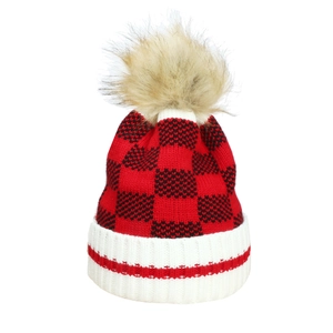 Close-up of red and black checkered knit beanie with large khaki faux fur pom-pom