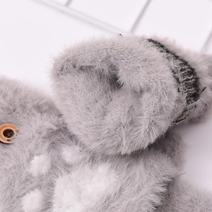 Close-up of gray knitted glove showing plush lining, ribbed cuff and wooden button detail