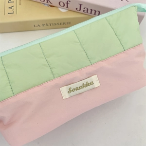 Detail of quilted stitching and Sezakka logo on pink and green pastel pencil case