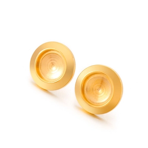 Detail view of golden concave round ear stud bases with polished metallic finish