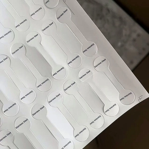 Detailed macro view of white dumbbell-shaped jewelry labels with Stainless Steel text
