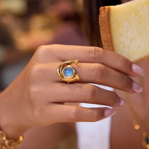 Golden equestrian resin ring with moonlight stone effect worn on hand in lifestyle shot