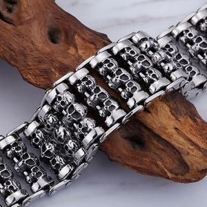 Punk men's titanium steel skull bracelet with vintage silver finish on wood base