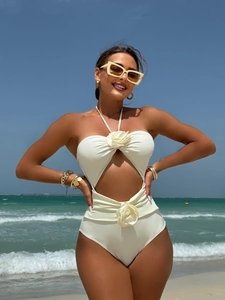 Detail of cream white cut-out swimsuit with 3D floral appliqués and halter neckline