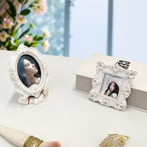 Detail of vintage white resin photo frames with intricate floral relief carvings
