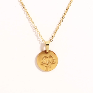 Close-up of gold titanium steel oval pendant with intricate floral rose engraving