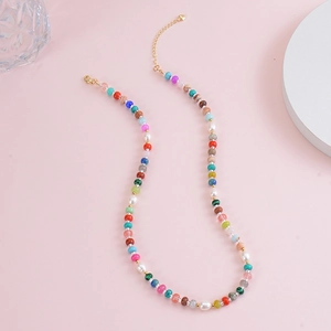 Detail of bohemian colorful gemstone beads and freshwater pearl necklace with gold clasp