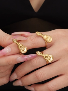 Detailansicht von 18k vergoldeten, verstellbaren Ringen in Gitarrenform am Finger