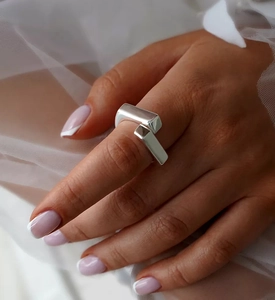 Close-up of geometric S925 sterling silver crisscross open ring on model hand