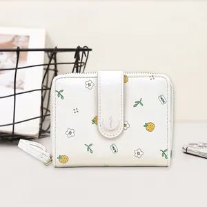 Close-up of floral bifold wallet with gold zipper and textured white leather detail