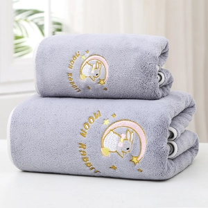 Detail of coral fleece towel featuring embroidered moon rabbit and plush texture