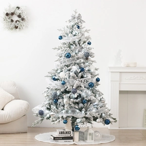 Close-up of white flocked Christmas tree with elegant blue and silver bauble ornaments