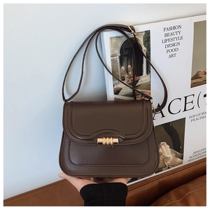 Détail du sac à bandoulière en cuir marron foncé vintage avec fermoir métallique doré