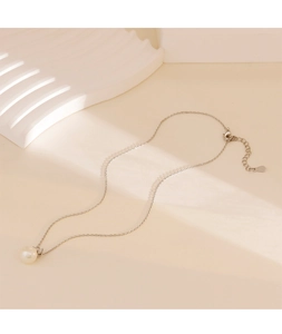 Detailed macro view of the white round pearl pendant on a polished silver snake chain
