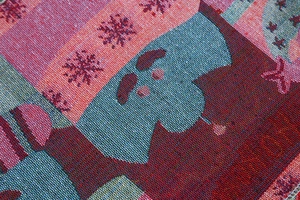 Close-up of knit fabric texture showing snowflake jacquard pattern for Christmas table runner
