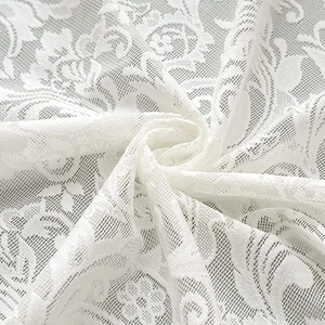 Elegant white lace curtain featuring floral patterns and a soft flowing texture draping