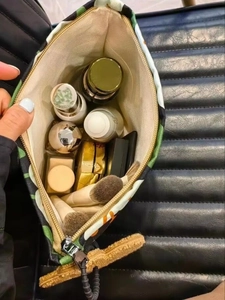 Top view of tropical canvas makeup bag showing interior storage for cosmetics and brushes