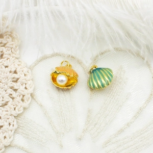Detailed macro shot of 18K gold-plated shell pendants with pearls and colorful enamel