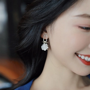 Elegant silver flower drop earrings with rhinestones and pearls worn by a model