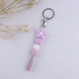 Close-up of purple silicone beads and leather tassel keychain with a flower bead detail
