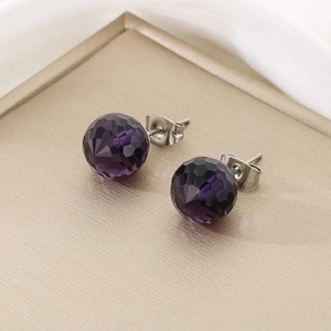 Detailed view of dark purple faceted crystal earrings with silver-toned butterfly backs