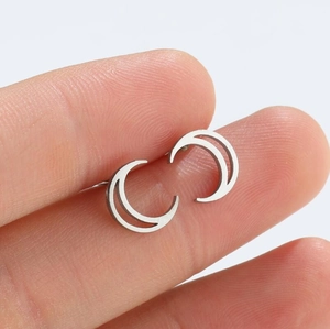 Minimalist silver geometric crescent moon stud earrings shown on fingers for scale