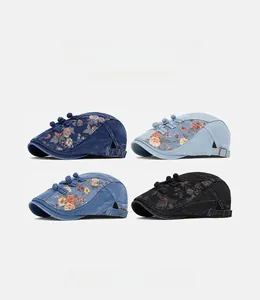 Détail de quatre bérets en jean avec broderies florales et boutons chinois traditionnels