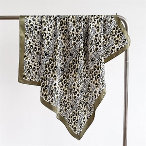 Detail of leopard print satin silk scarf with army green border on metal hanger