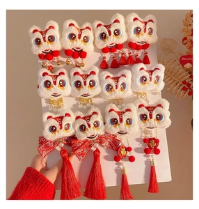 Detail of plush lion dance hair clips with red tassels, gold bells and pearl accents