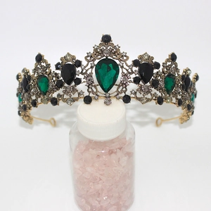 Detail of vintage gold crown featuring teardrop green and black crystal gemstones