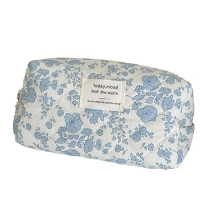 Floral quilted cotton makeup bag in blue begonia print with zipper and woven label