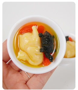 Dettaglio ravvicinato del portachiavi miniatura realistico di zuppa di pollo e tartaruga