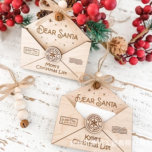 Detail of wooden Christmas envelope ornaments with Santa letter engraving and red berries