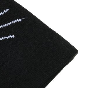 Close-up of black knitted fabric with white sawtooth stitching detail and texture