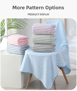 Detailed view of wave-patterned coral fleece bath towels in various pastel colors